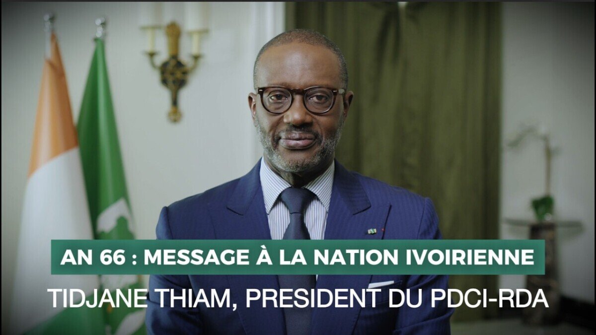 Man in a navy suit delivering a formal address; on-screen banner reads 'AN 66: MESSAGE A LA NATION IVOIRIENNE' with party title.